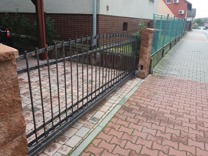 Zděný plot a kovaná pojezdová brána
